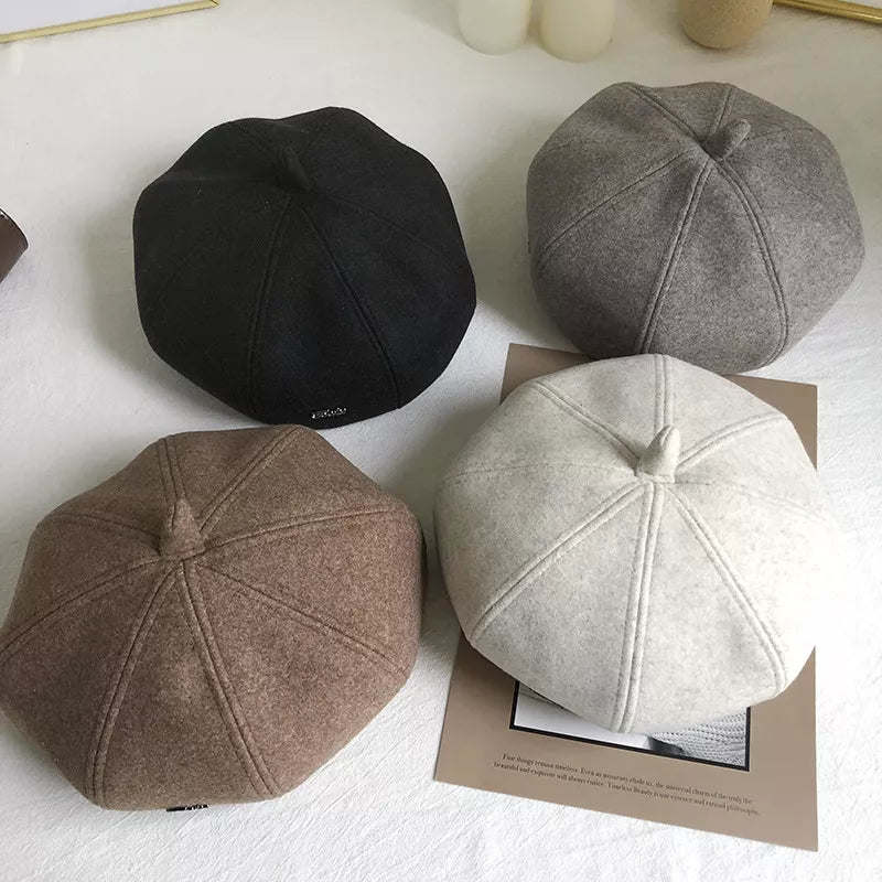 Woolen beret with distinct paneled design in ivory, khaki, beige, and black.
