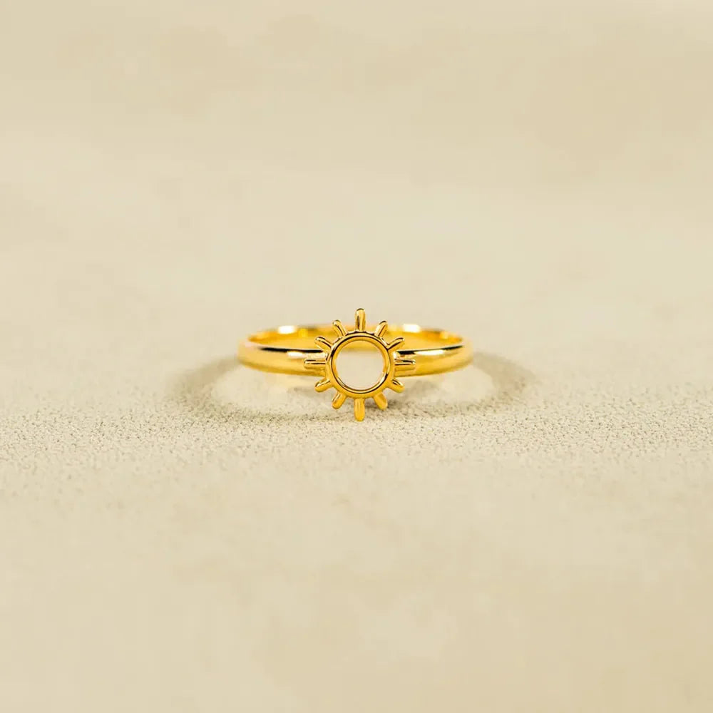 Gold sunburst signet ring with a cut-out center detail.
