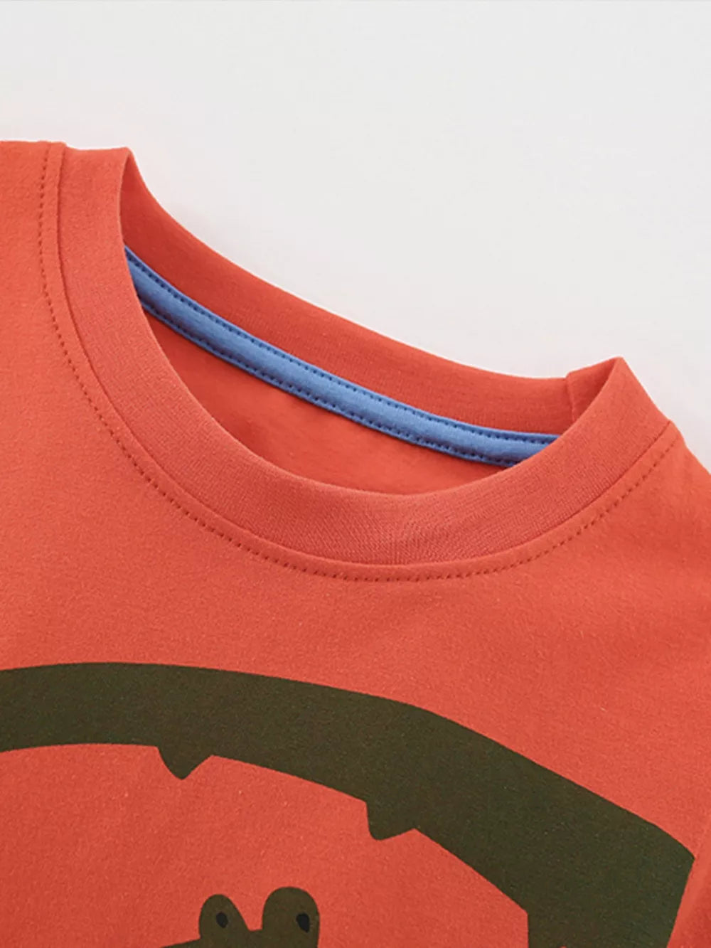 Coral cotton toddler t-shirt with playful green crocodile graphic and blue trim neckline.