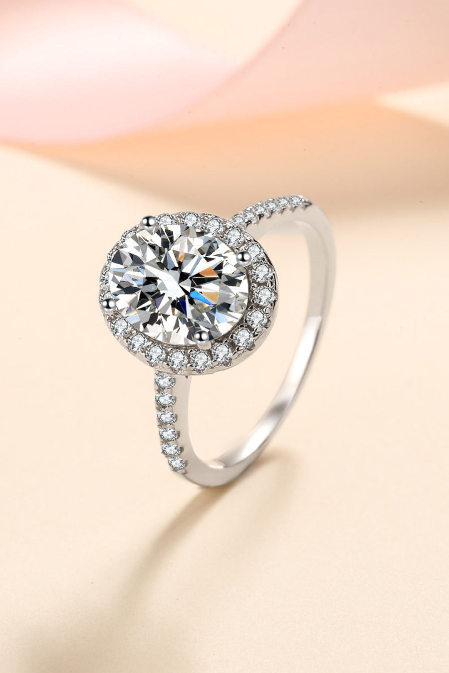 Silver pavé halo solitaire ring with a round-cut center stone and embellished band.