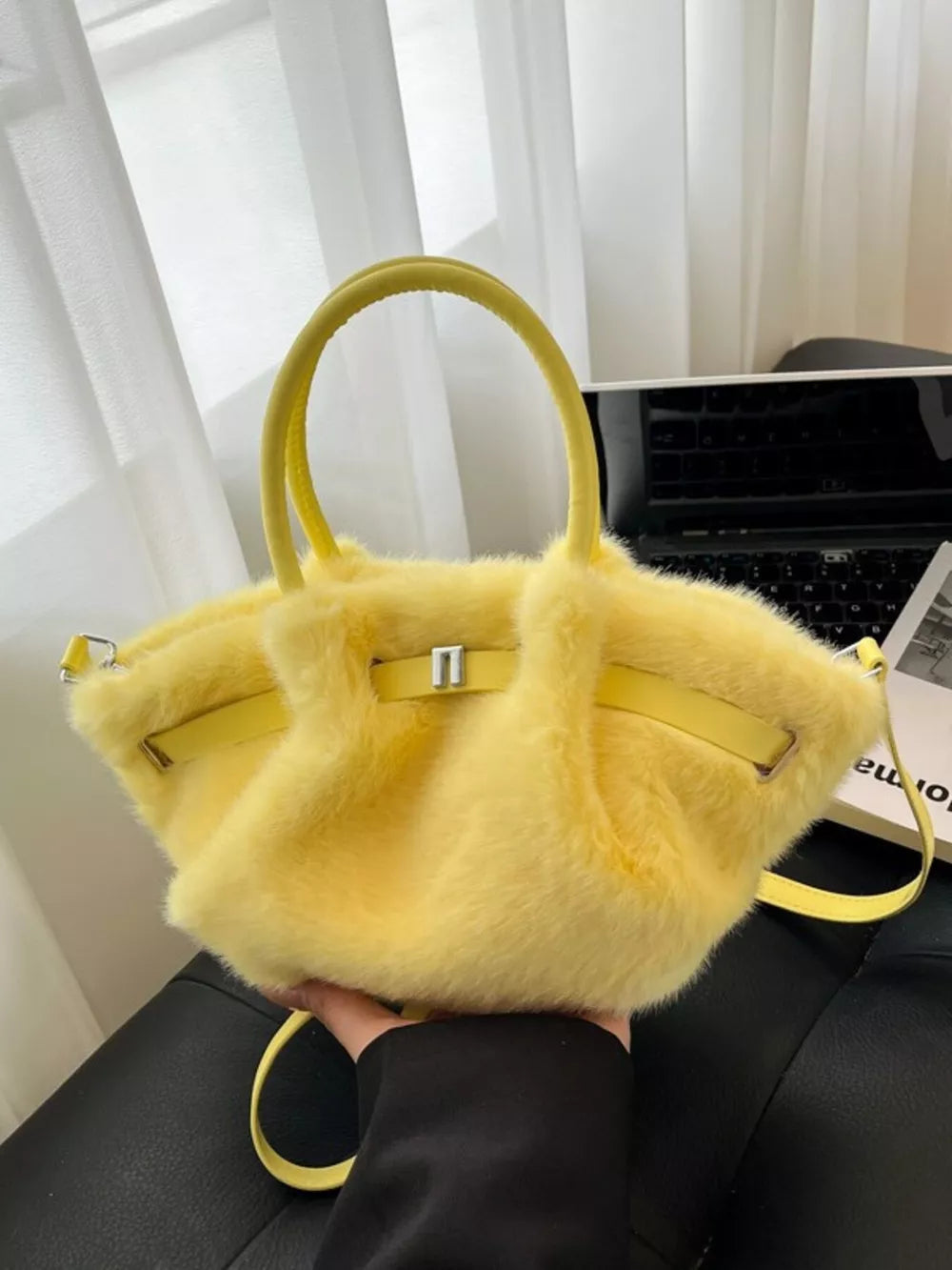 Yellow plush crossbody bag with chic buckle detail and top handles.