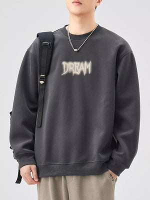 Oversized dark gray crew-neck sweatshirt with a distressed "DREAM" graphic on the front.