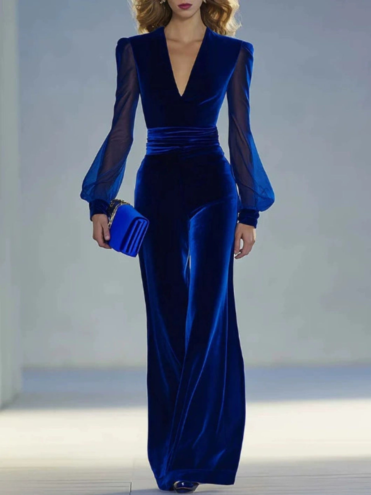 Royal blue velvet jumpsuit with sheer balloon sleeves and wide-leg pants.