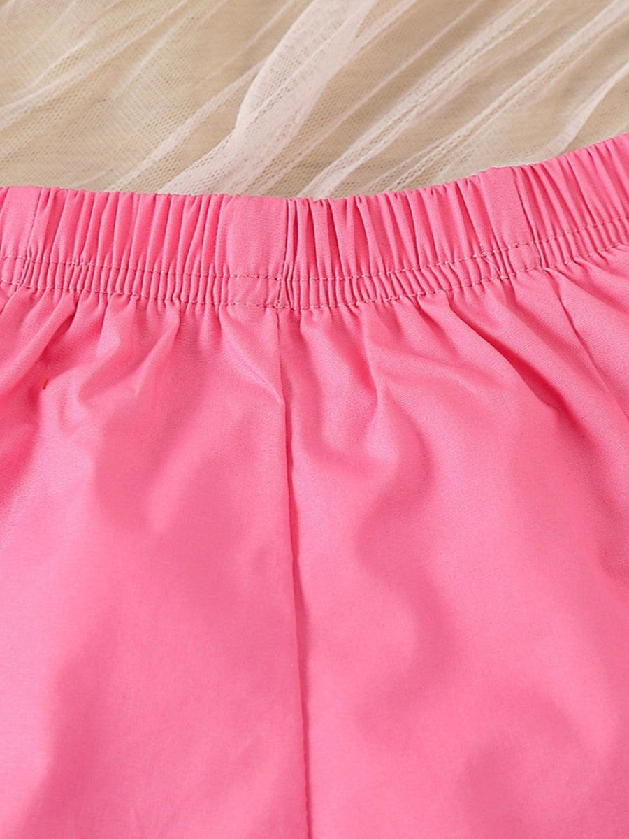 Bright pink baby shorts with elastic waistband and ruffled trim detail.