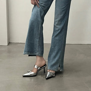 Silver pointed buckle mule heels with a strap and buckle detail.