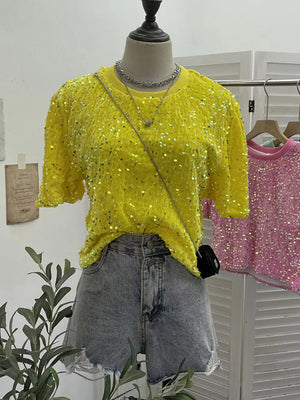 Yellow crew neck t-shirt with iridescent sequins, short sleeves, styled with denim shorts.