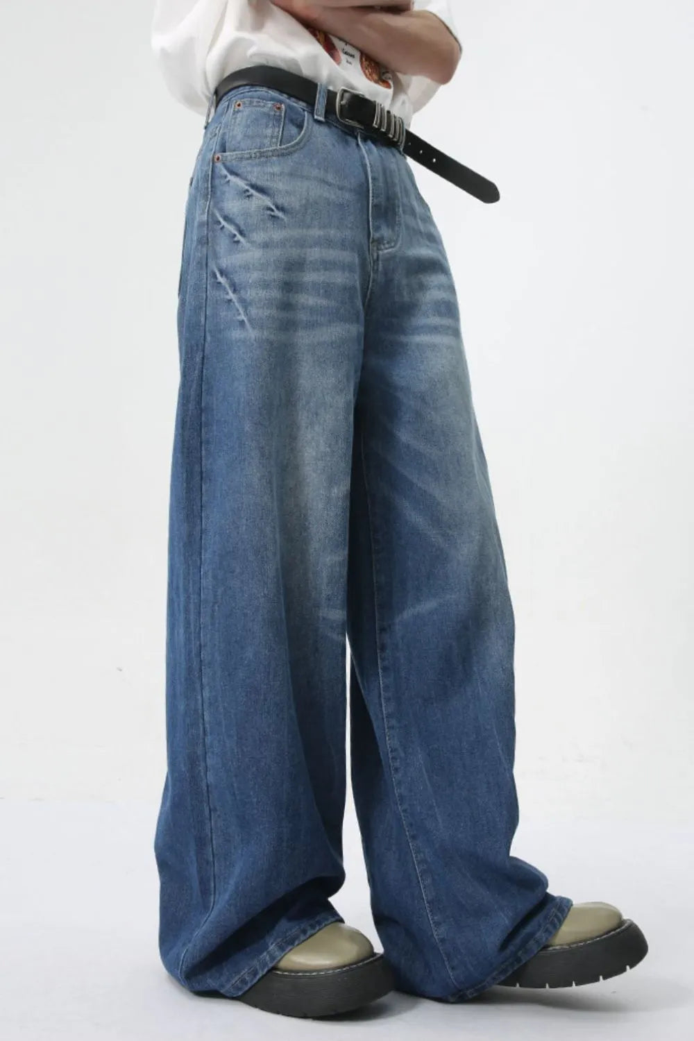 Oversized denim palazzo trousers in medium wash with distressed details and a wide leg.