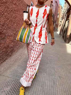 Red fish print sleeveless top and wide-leg pants set with gold button details.