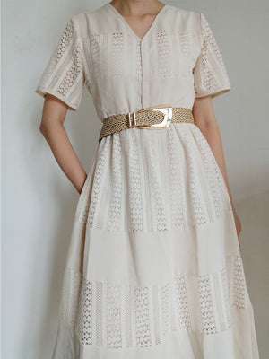 Woven raffia belt with gold-tone buckle, styled with a white lace dress.