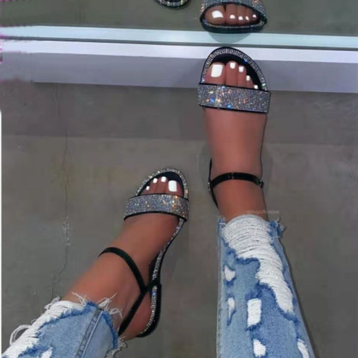 Black rhinestone-embellished flat ankle sandals with a thin ankle strap.