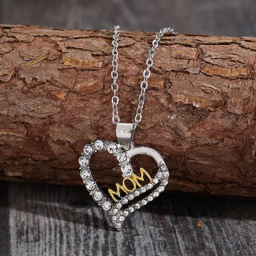 Silver heart necklace with crystal accents and gold MOM lettering.