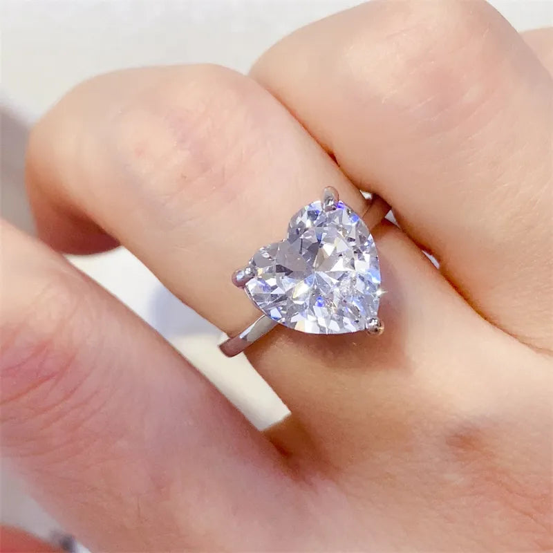 Silver ring with a large, brilliant heart-cut moissanite solitaire.