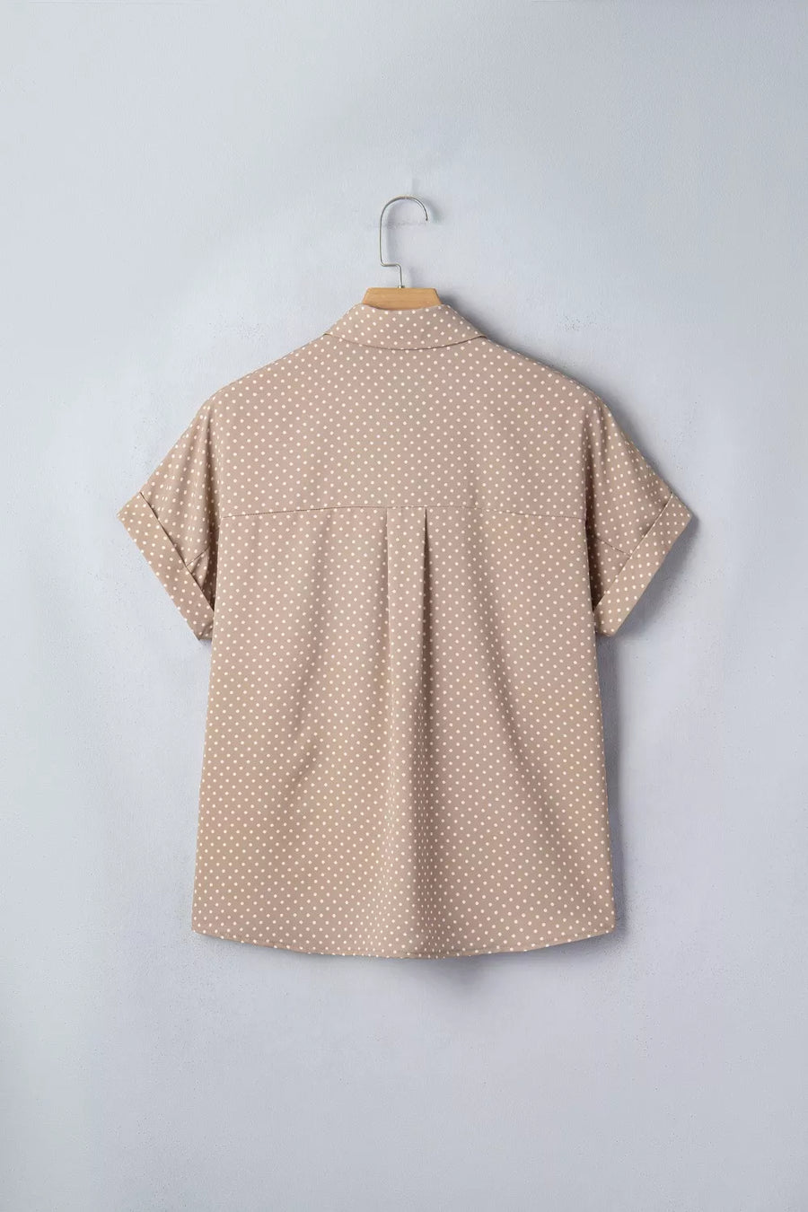 Chic polka dot button-up shirt with cuffed short sleeves and a collared neckline.