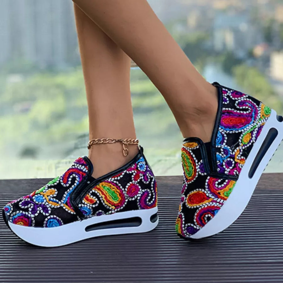 Paisley print slip-on shoes with a chunky white platform sole.