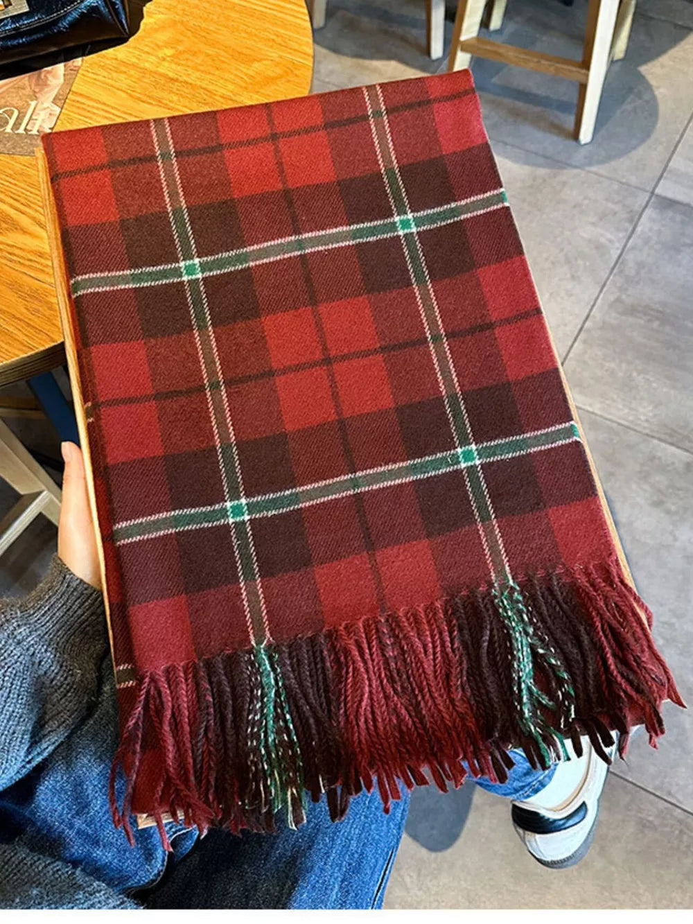 Red plaid scarf with fringe detail and green accents.