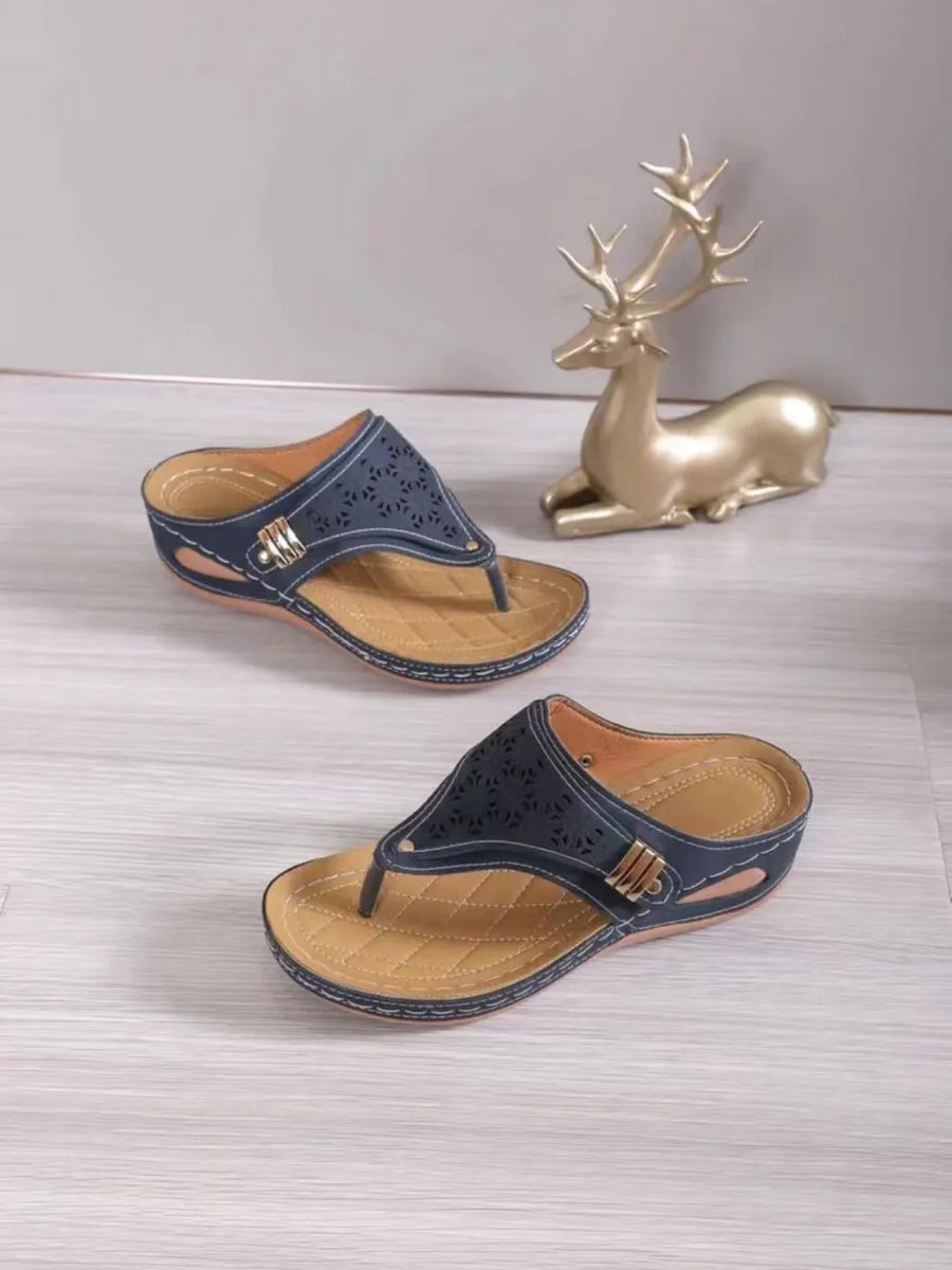 Laser-cut comfort thong sandals in Dusty Blue with quilted tan footbed and gold buckle detail.