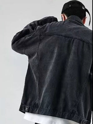 Men's black denim trucker jacket with button details and classic stitching.
