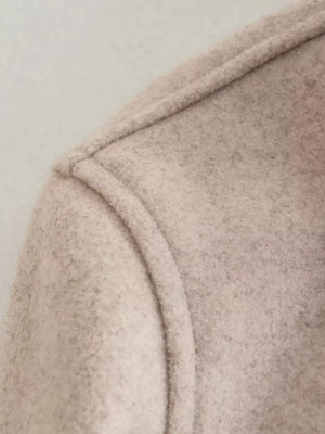 Beige trucker jacket detail showing seam and textured fabric