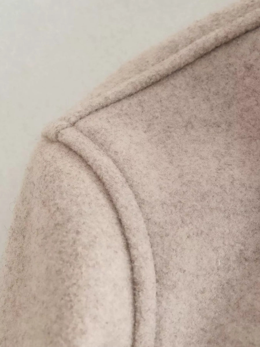 Beige trucker jacket detail showing seam and textured fabric