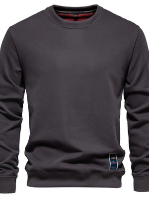 Gray crewneck sweatshirt with subtle patch detail on hem