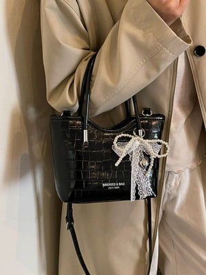 Black crossbody bag featuring top handle and animal-print