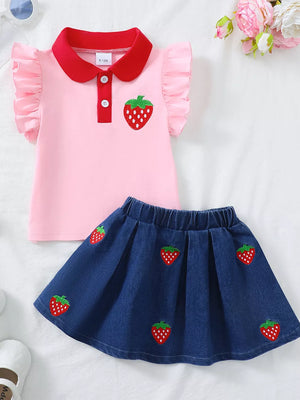 Pink polo top with strawberry embroidery and red collar, paired with a denim skirt with strawberry pattern.