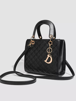 Mini quilted top-handle tote bag in black with gold hardware and a decorative 'D' charm.