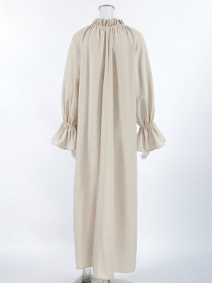 Beige cotton maxi dress with tie neck, ruffled collar, and ruffled cuffs.