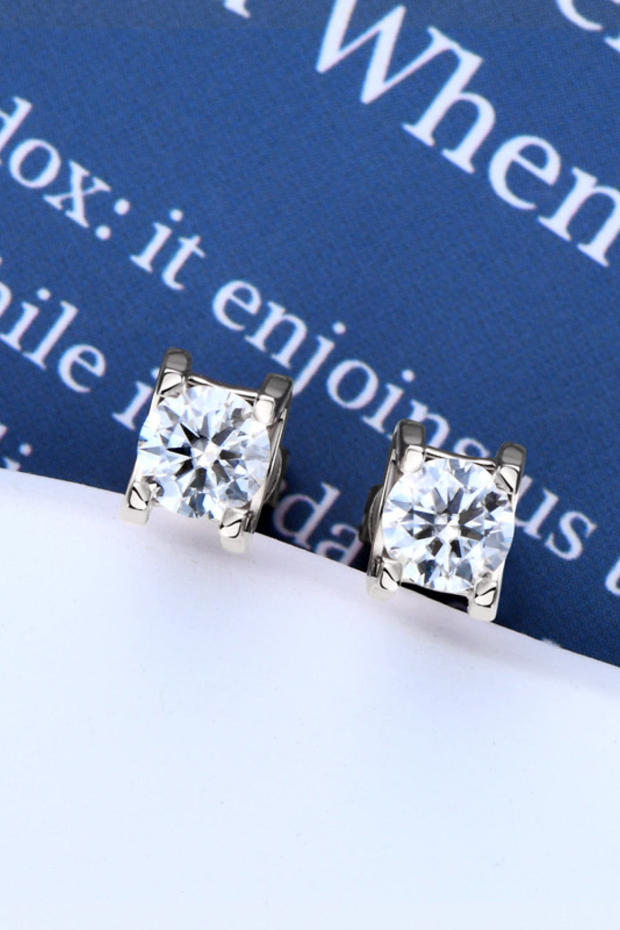 Rose gold moissanite solitaire stud earrings with four-prong setting.