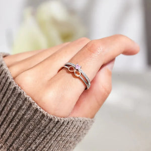 Silver infinity heart ring set with pink stone and diamond accents.