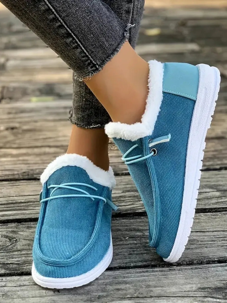 Pastel blue corduroy slip-on sneakers with white sherpa lining and white soles.