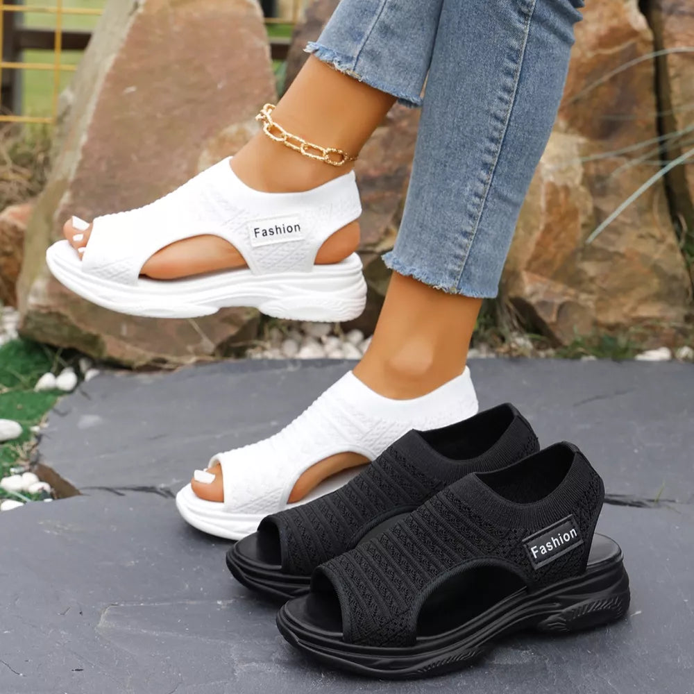 White and black sporty chunky platform sandals with breathable knit uppers and a comfortable sole.