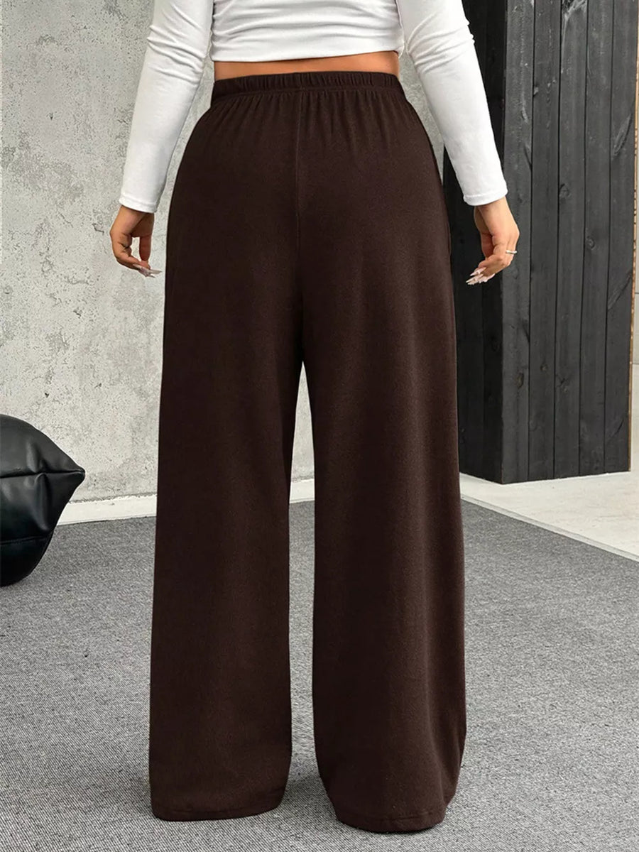 Brown maternity pants with wide legs and a drawstring waist, shown from the back.