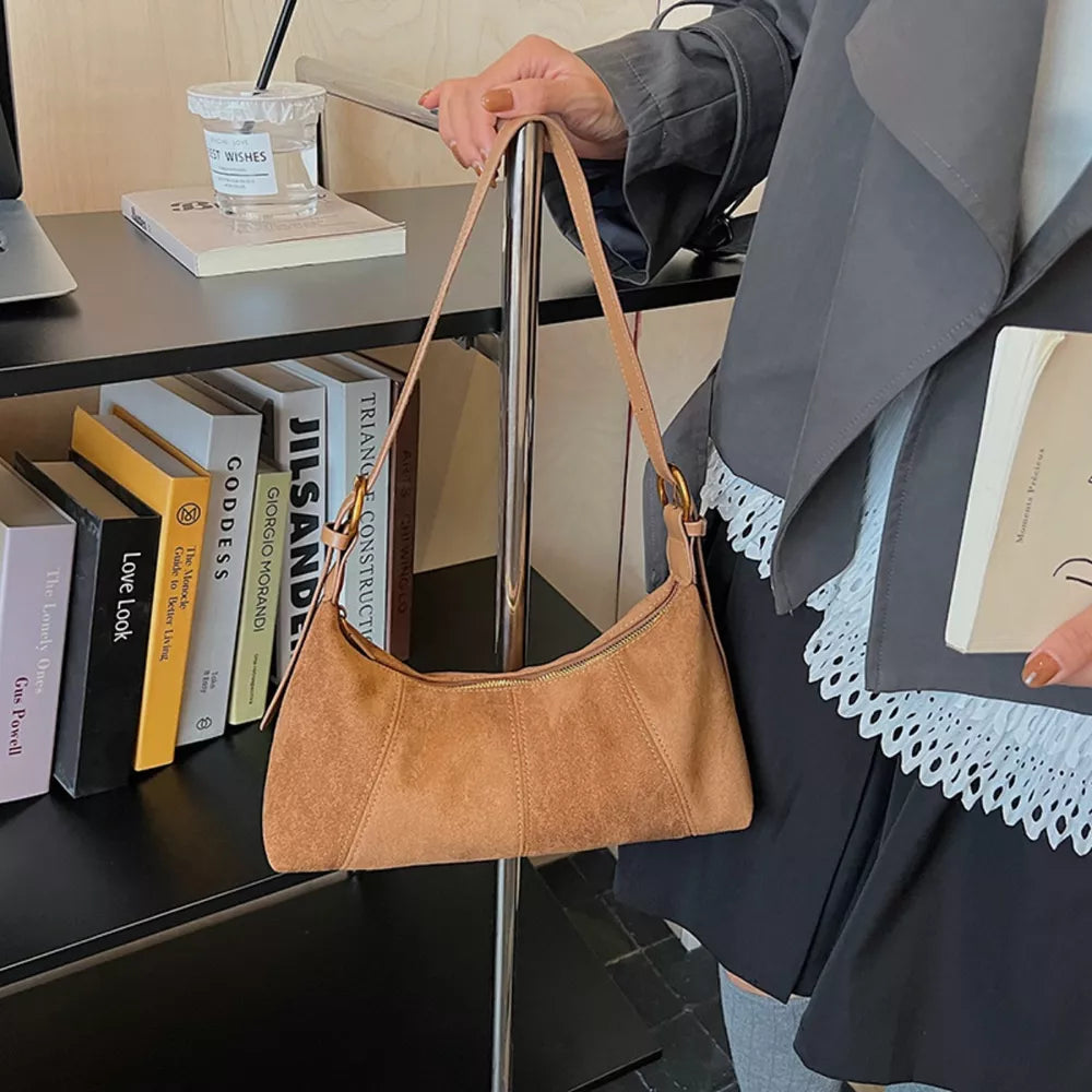Chic suede crescent shoulder bag in coffee brown with adjustable strap.
