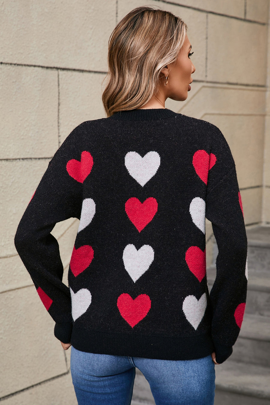 Black crewneck knit pullover with allover red and white heart motif.