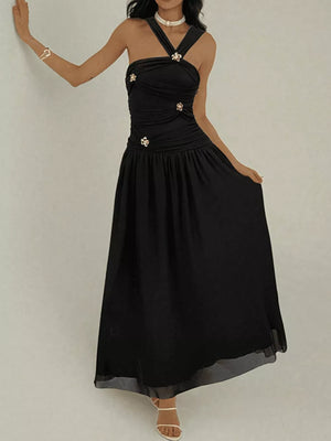 Black ruched sleeveless maxi dress with embellishments and a halter neckline.