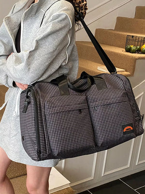 Chic medium plaid duffel bag with multiple exterior pockets and a black strap.