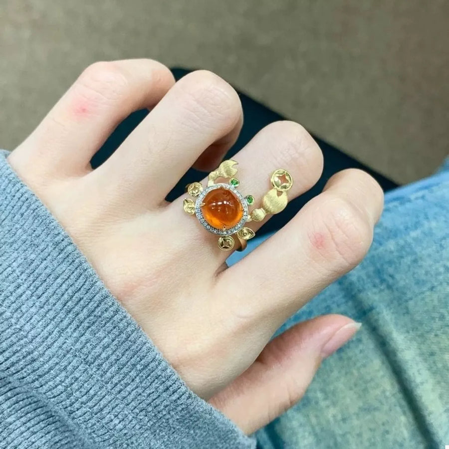 Gold crab ring with orange gemstone and green accents