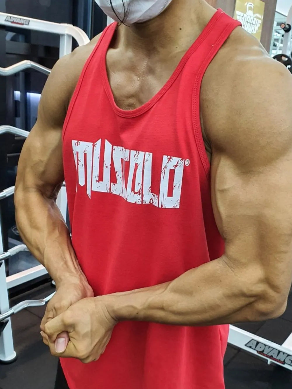 Red muscle tank top with distressed white logo graphic, round neck, sleeveless.