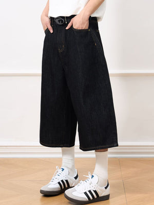 Men's relaxed fit black denim culotte shorts with a wide leg and raw hem.