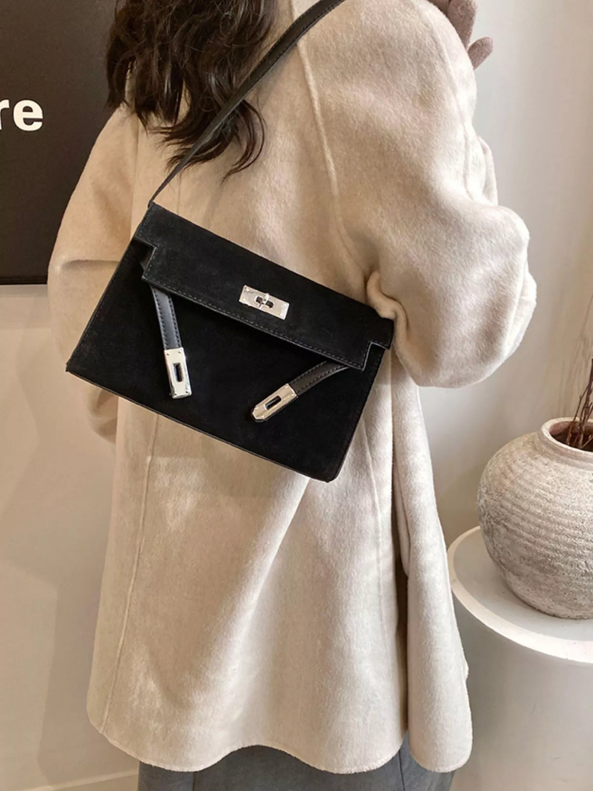 Black suede shoulder bag with silver buckle detail and leather accents