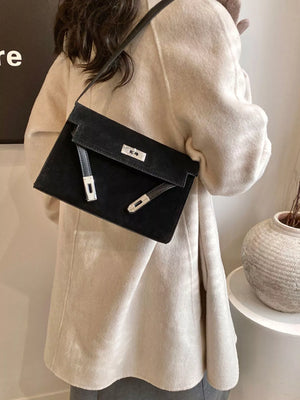 Black suede shoulder bag with silver buckle detail and leather accents