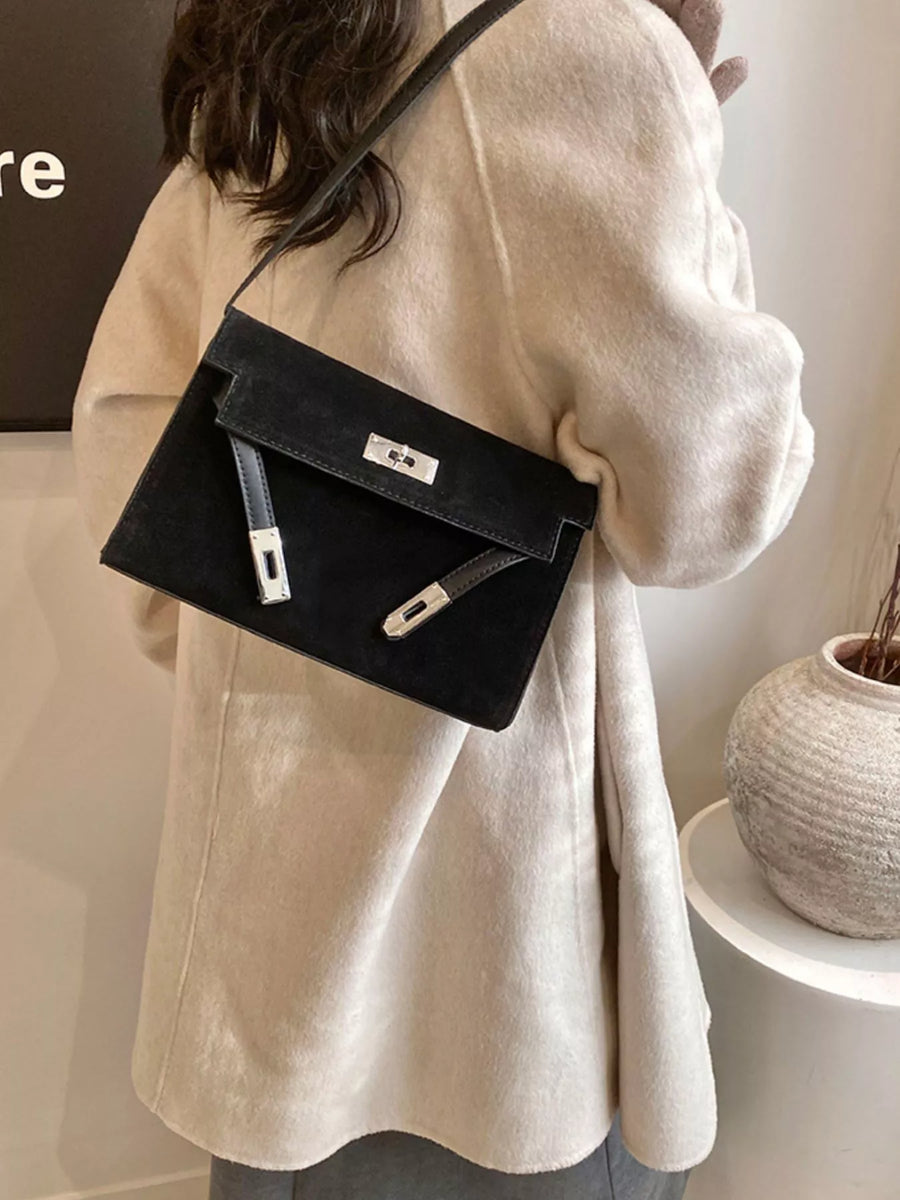 Black suede shoulder bag with silver buckle detail and leather accents