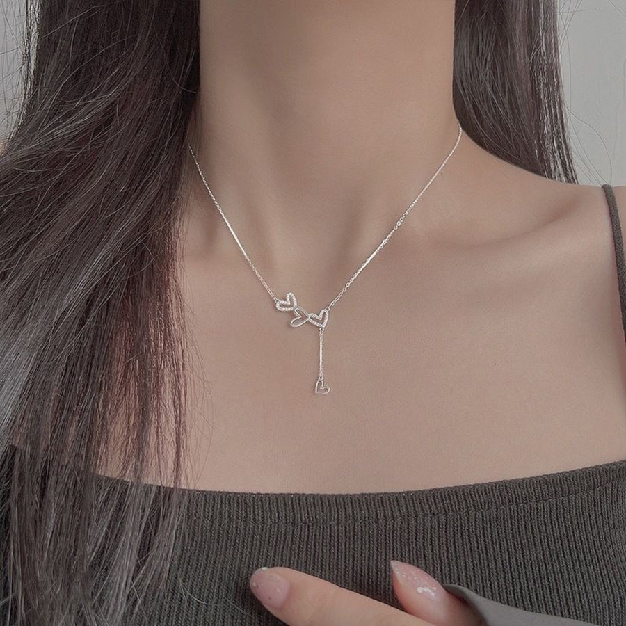 Sterling silver Y-necklace with delicate heart charms and a dangling heart pendant.