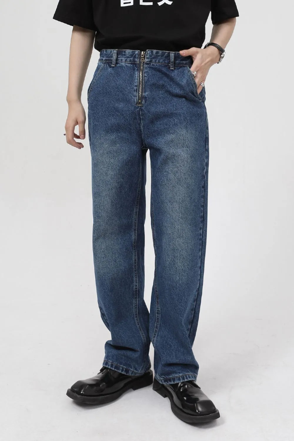 Zip-front relaxed fit medium wash denim jeans with a baggy cut.