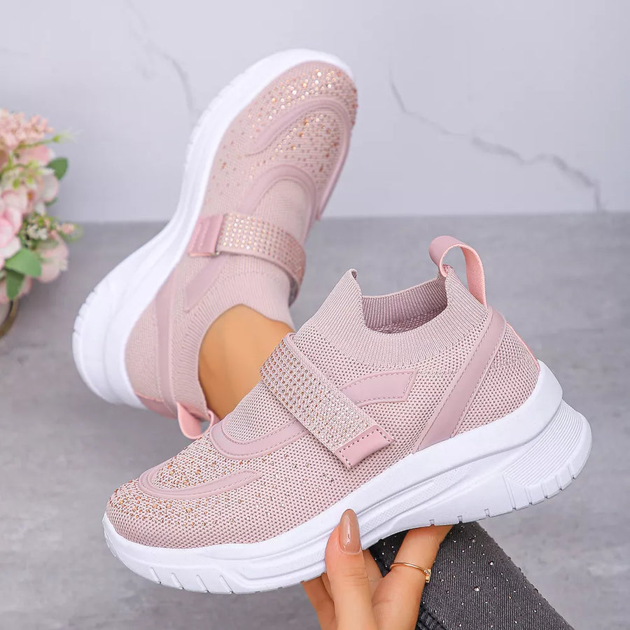 Pink mesh slip-on sneakers with adjustable straps and rhinestone embellishments.