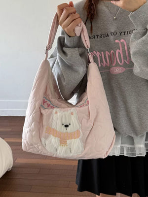 Blush pink quilted crossbody bag with a white bear applique wearing a pink scarf.