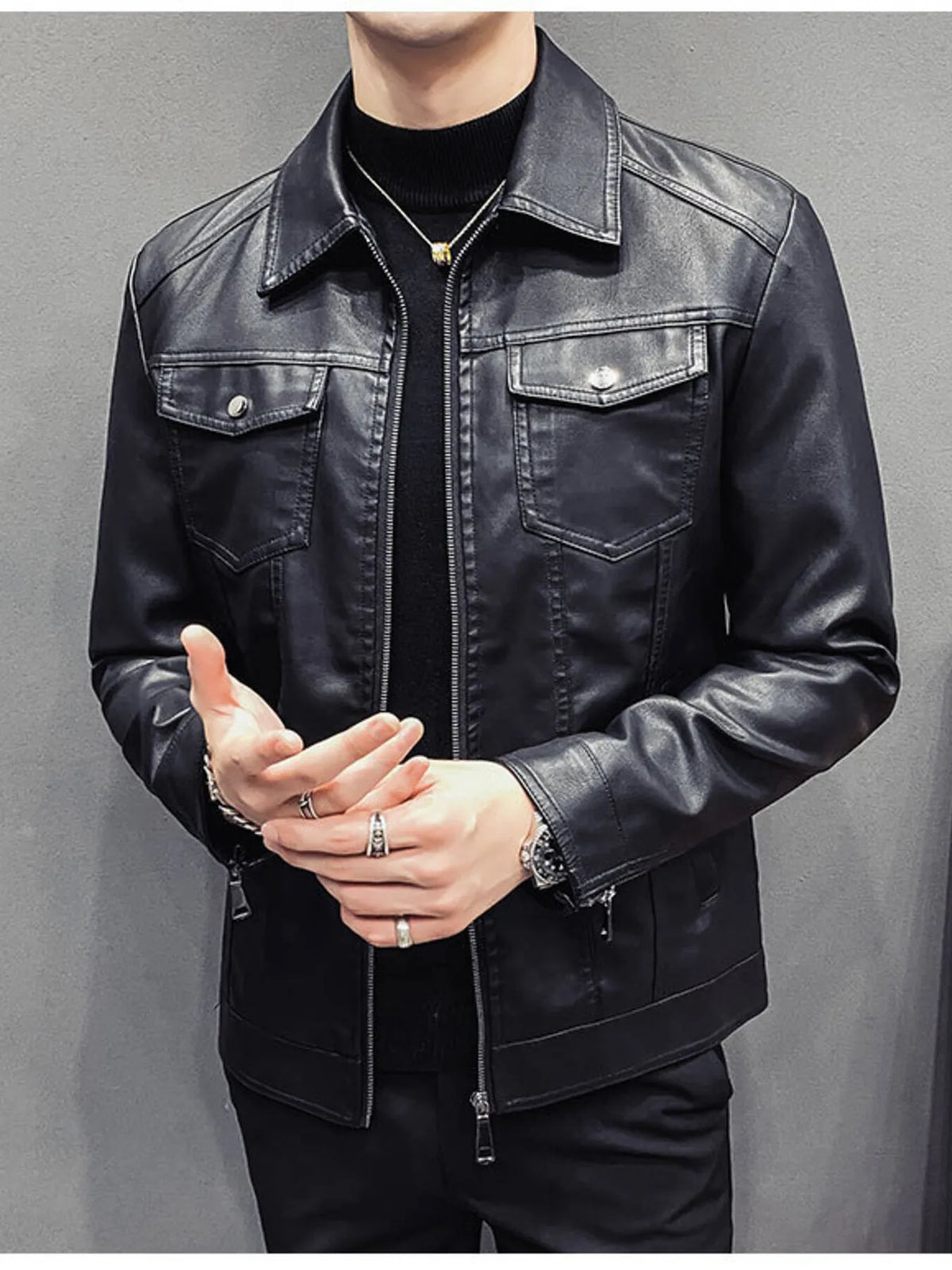 Men's black faux leather trucker jacket with chest pockets and zipper closure.