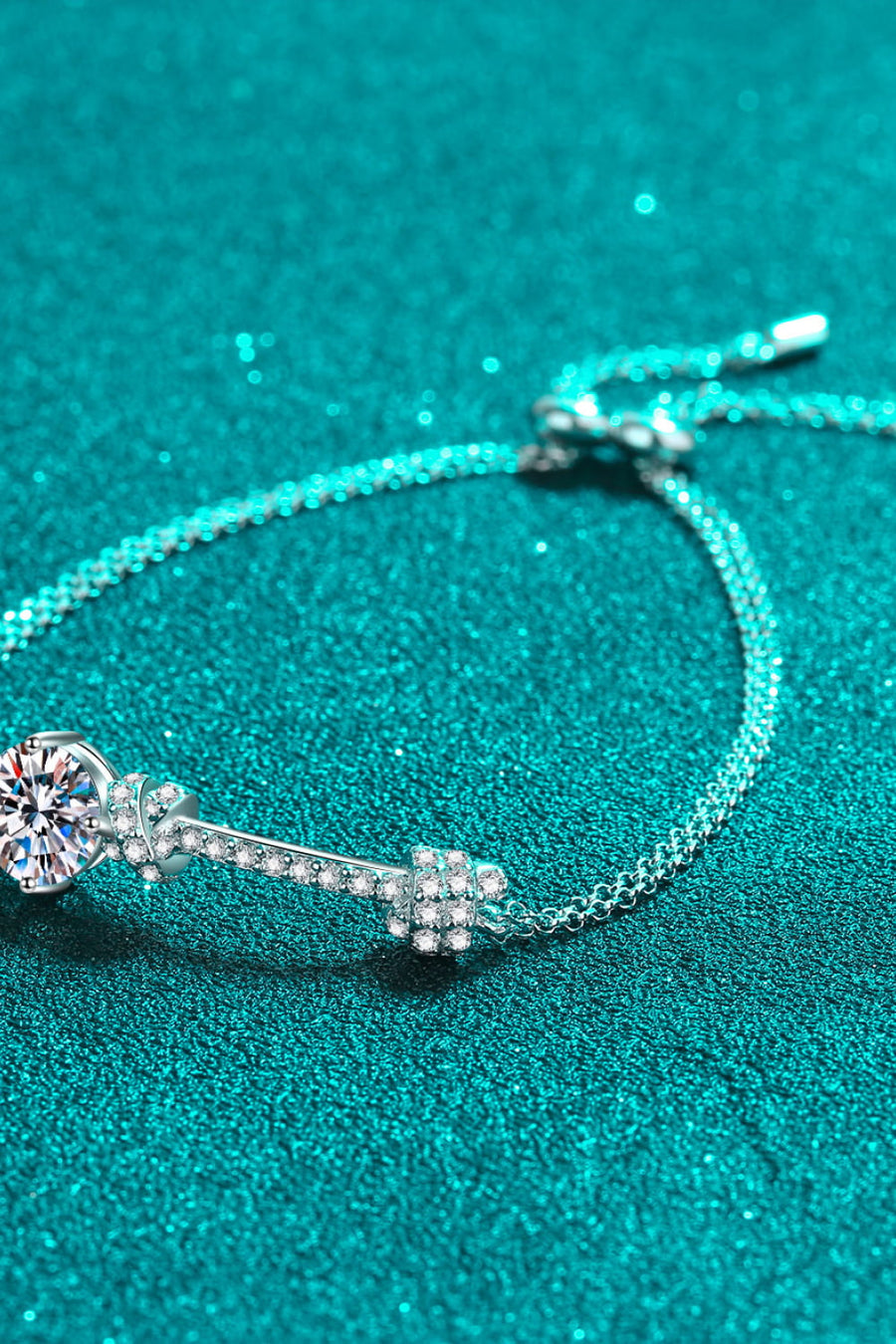 Silver bracelet with a large diamond-like charm and cubic zirconia accents.