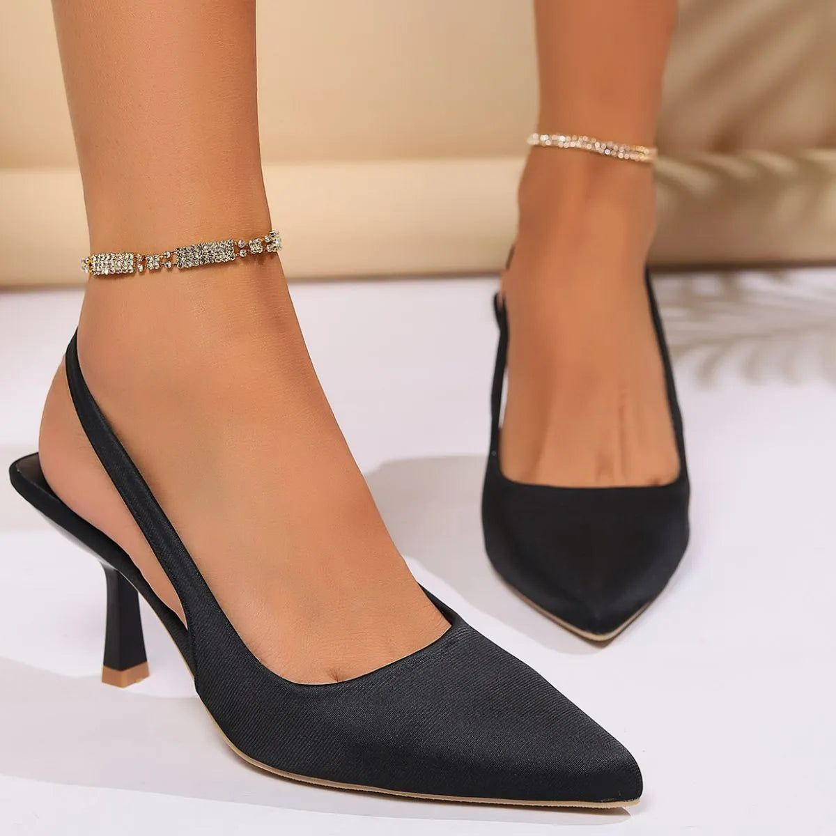 Black slingback pointed kitten heels with a delicate rhinestone anklet.